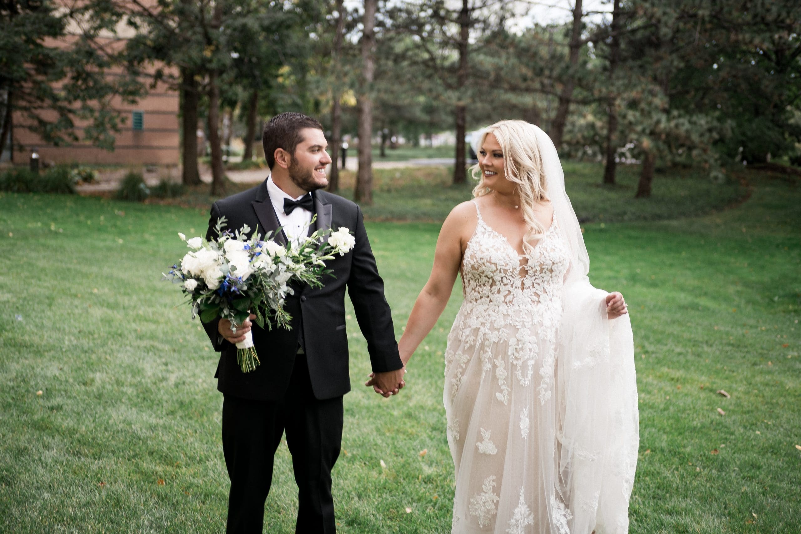 A camera-shy couple sharing a natural, candid moment during their wedding portraits, captured in a relaxed documentary photography style